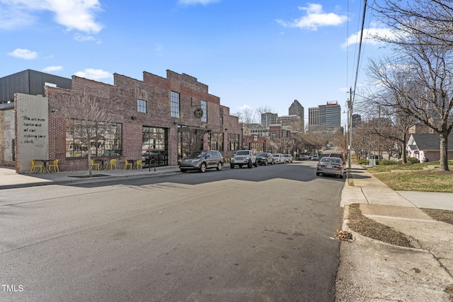 view of road with sidewalks, a view of city, and curbs