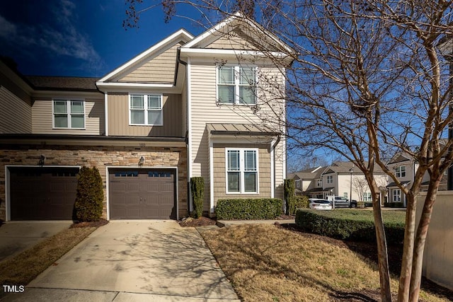 view of front of home featuring a garage, stone siding, and driveway