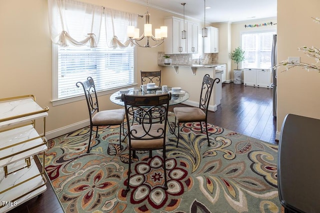 dining room with baseboards, an inviting chandelier, dark wood-style flooring, and crown molding