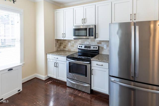 kitchen with light stone countertops, dark wood finished floors, decorative backsplash, appliances with stainless steel finishes, and white cabinetry