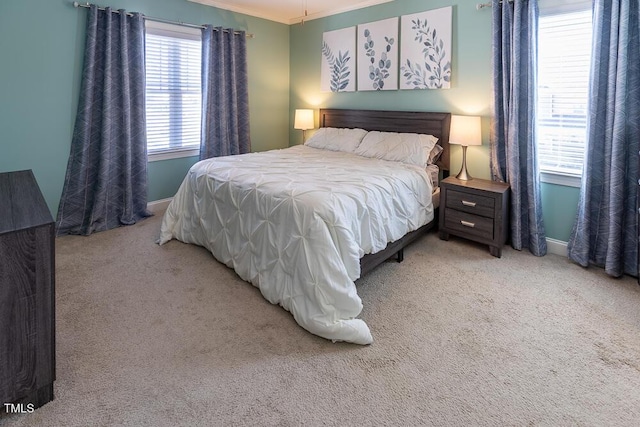 bedroom with baseboards, light colored carpet, and ornamental molding