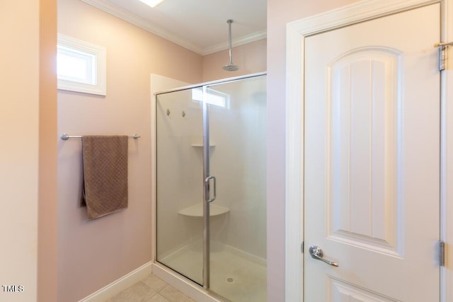 bathroom with tile patterned floors, baseboards, ornamental molding, and a shower stall