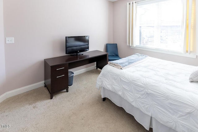 bedroom featuring light carpet and baseboards