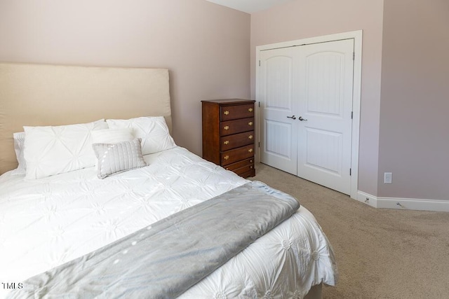 bedroom with a closet, carpet flooring, and baseboards