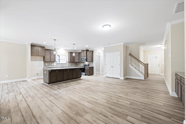 1987 Meadowview Dr, Graham, NC 27253 - kitchen featuring light countertops, visible vents, light wood finished floors, appliances with stainless steel finishes, and dark brown cabinetry