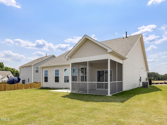 rear view of house featuring a sunroom, fence, a patio, and a lawn