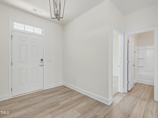 foyer entrance with baseboards, visible vents, and light wood-style floors