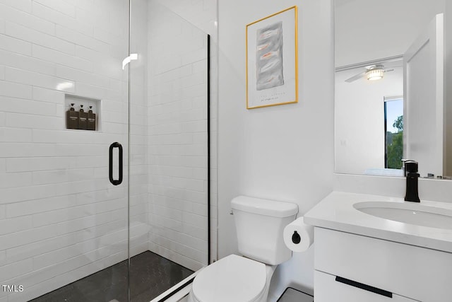 bathroom with a stall shower, vanity, and toilet