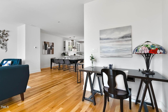 dining space featuring light wood finished floors and baseboards