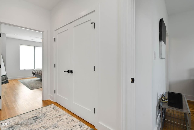 corridor featuring wood finished floors and baseboards