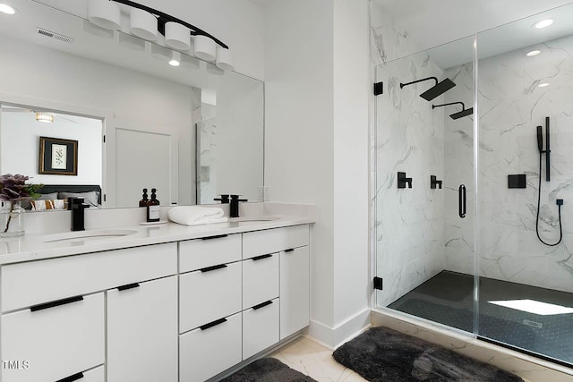 bathroom featuring marble finish floor, visible vents, a sink, and a marble finish shower