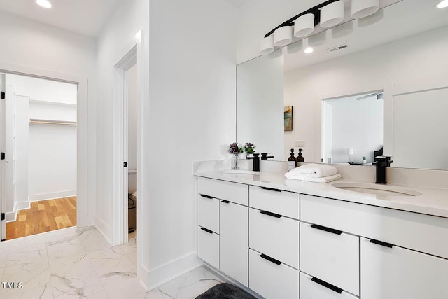 full bath with marble finish floor, double vanity, a sink, and visible vents