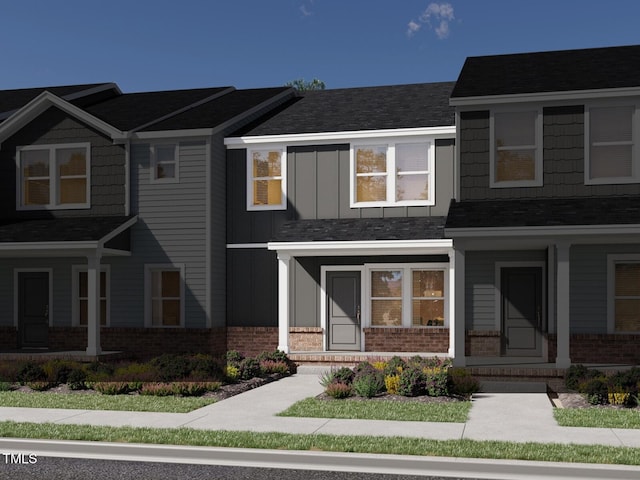 view of front facade featuring a porch, brick siding, and board and batten siding