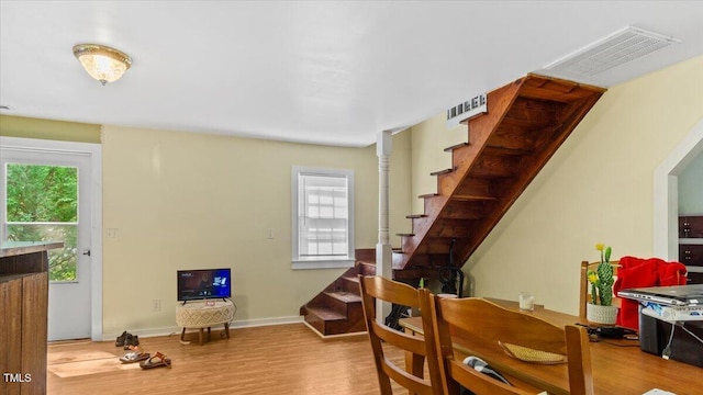 interior space featuring wood finished floors, visible vents, baseboards, and stairs