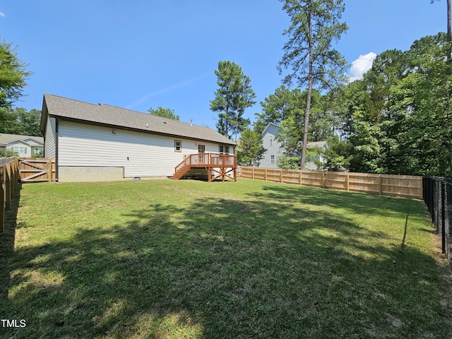 view of yard with a fenced backyard, a wooden deck, and stairs