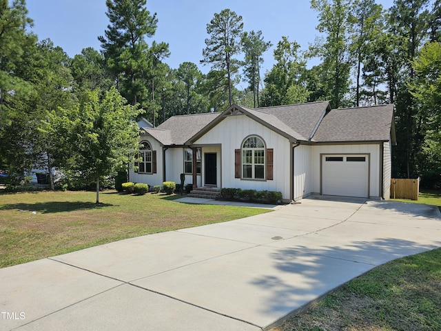 ranch-style home with a garage, driveway, a front lawn, and roof with shingles