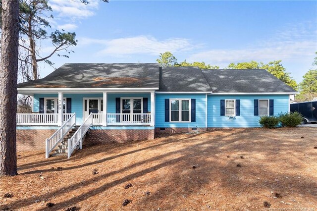 ranch-style home featuring a porch, crawl space, a front lawn, and stairs