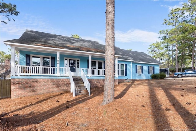 ranch-style home with a porch and stairs