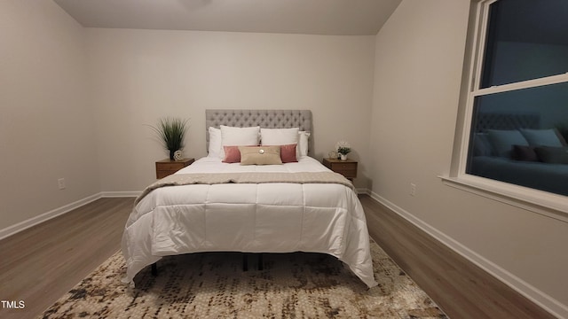 bedroom with baseboards and wood finished floors