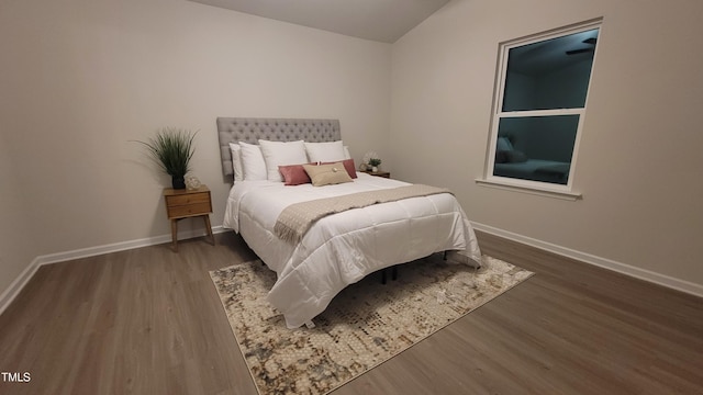 bedroom featuring vaulted ceiling, wood finished floors, and baseboards