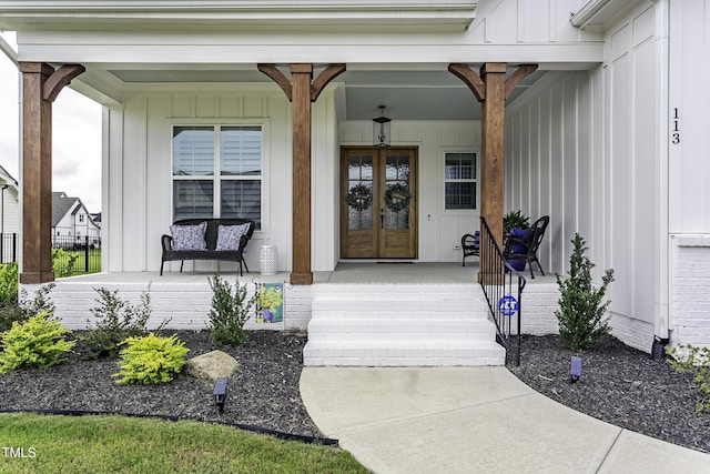 doorway to property featuring board and batten siding, french doors, and covered porch