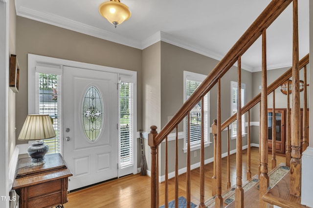 entrance foyer featuring stairs, ornamental molding, plenty of natural light, and light wood-style floors