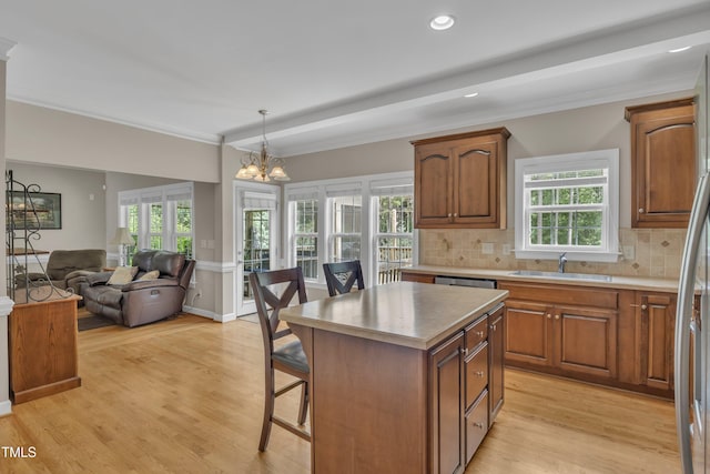 kitchen with a center island, a breakfast bar area, hanging light fixtures, open floor plan, and a sink