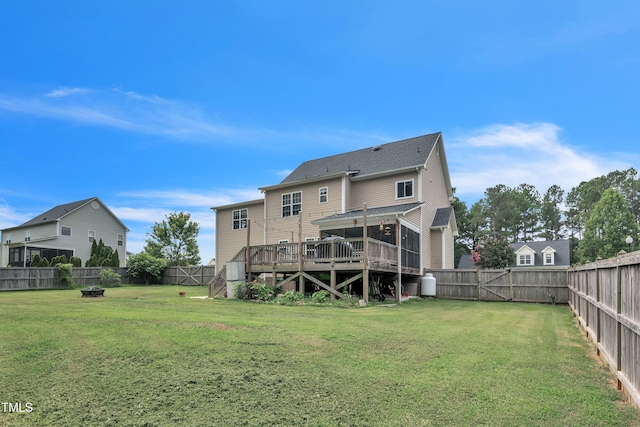 rear view of house featuring a yard, a fenced backyard, a wooden deck, and a gate