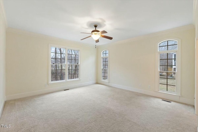 unfurnished room featuring ornamental molding, plenty of natural light, and light colored carpet