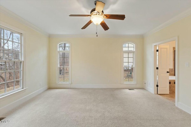 spare room featuring ornamental molding, light colored carpet, and plenty of natural light