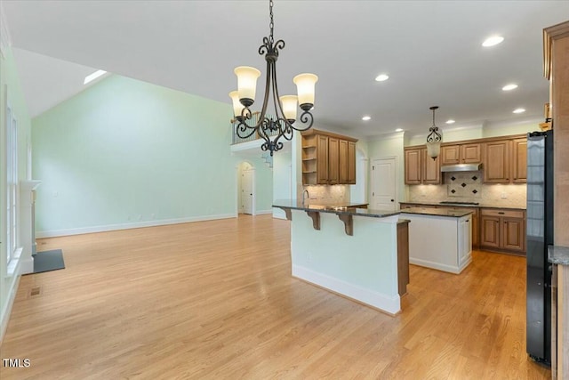 kitchen with open shelves, brown cabinetry, and decorative light fixtures