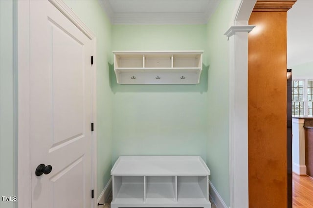 mudroom featuring decorative columns, baseboards, and crown molding