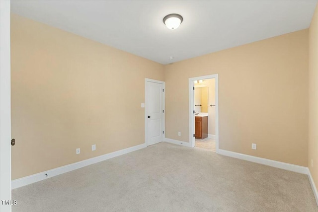 spare room with light carpet and baseboards