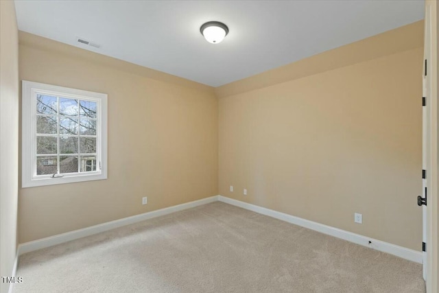 empty room featuring light carpet, visible vents, and baseboards