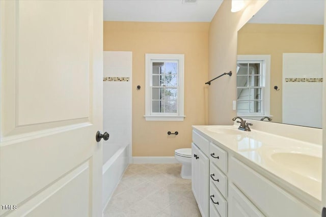 full bath featuring double vanity, a sink, toilet, and baseboards