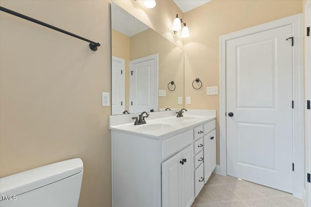 bathroom featuring double vanity, tile patterned flooring, a sink, and toilet