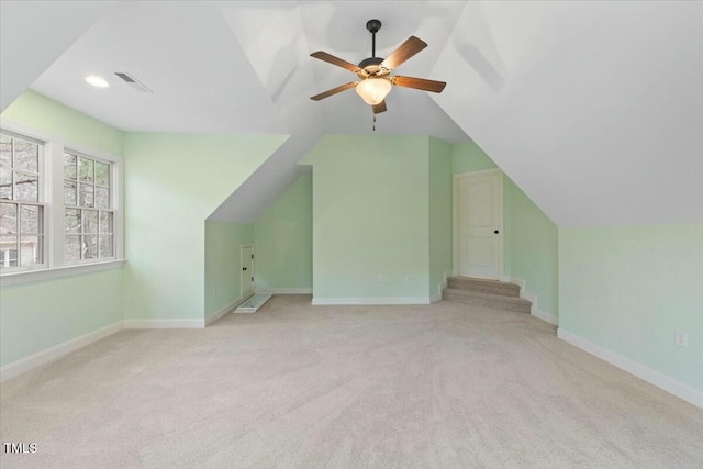 bonus room featuring lofted ceiling, light colored carpet, visible vents, ceiling fan, and baseboards