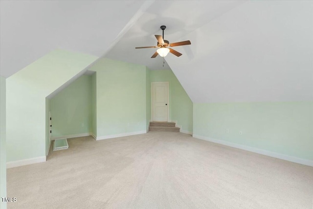 additional living space with baseboards, vaulted ceiling, and a ceiling fan