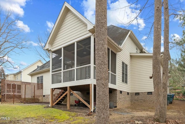 back of property featuring a yard, stairway, crawl space, and a sunroom