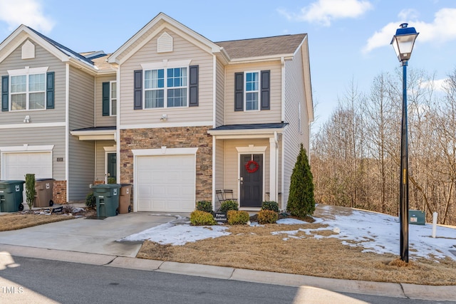 view of front of home featuring stone siding, an attached garage, and concrete driveway