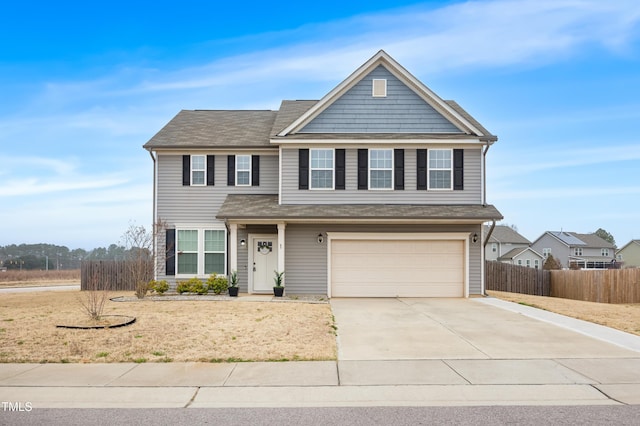 traditional-style home featuring a garage, driveway, and fence