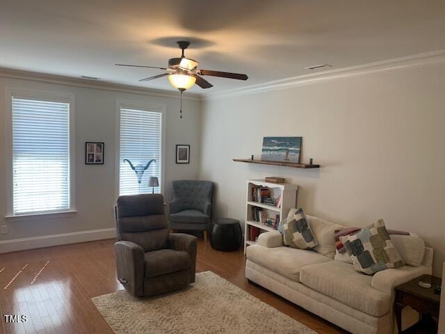 living area with a ceiling fan, baseboards, crown molding, and wood finished floors