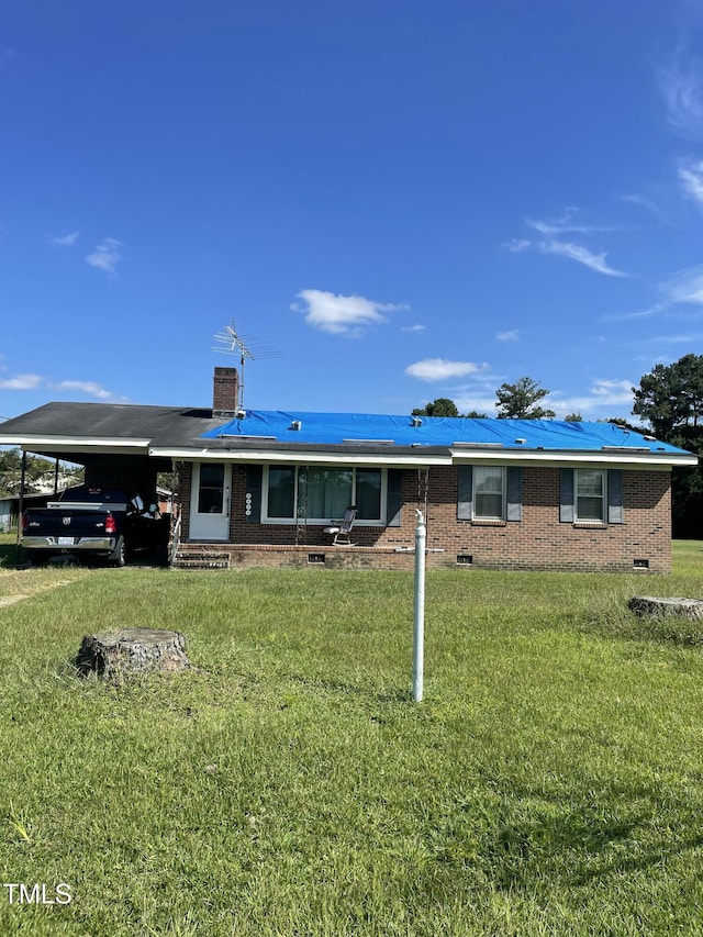 ranch-style house with a carport, a front yard, brick siding, and a chimney