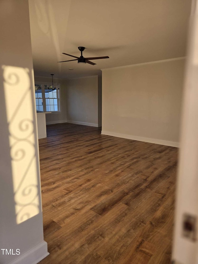 interior space with baseboards, a ceiling fan, and dark wood-type flooring