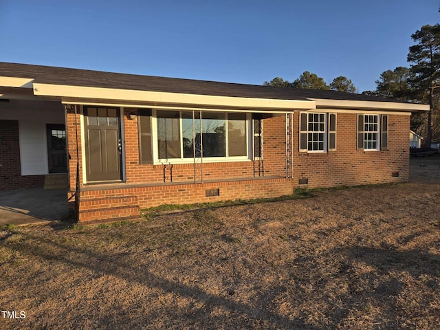 view of front facade with crawl space and brick siding