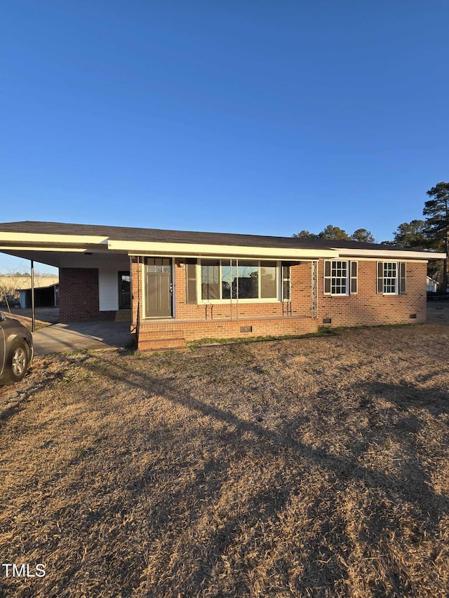 single story home featuring a carport, brick siding, and crawl space