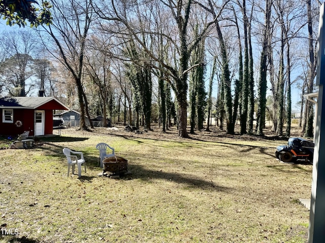 view of yard featuring an outdoor fire pit and an outbuilding