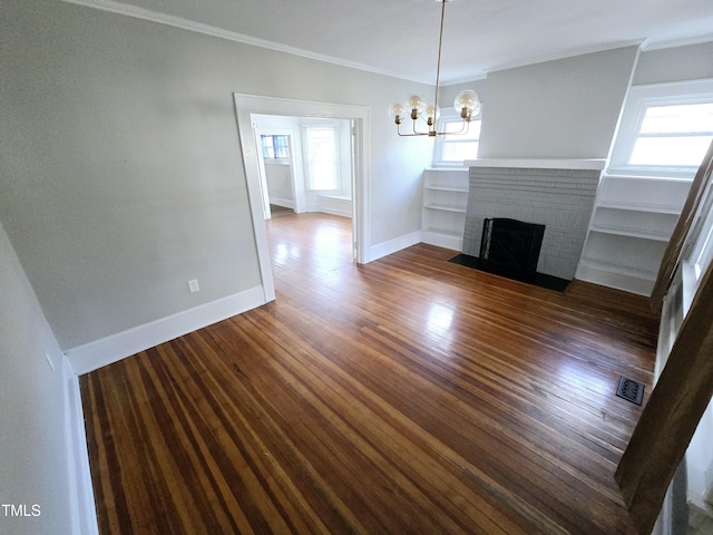 unfurnished living room with dark wood-style flooring, a fireplace, visible vents, baseboards, and crown molding