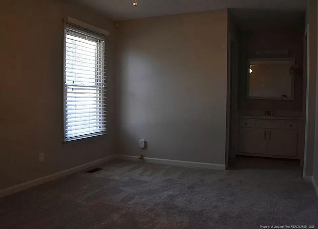 carpeted empty room featuring visible vents and baseboards