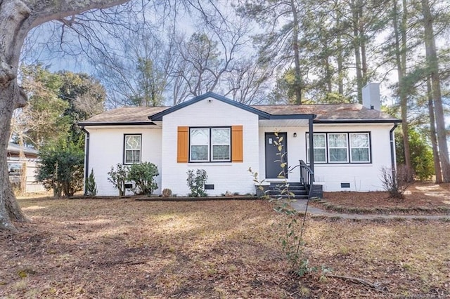 ranch-style home featuring roof with shingles, brick siding, crawl space, and a chimney